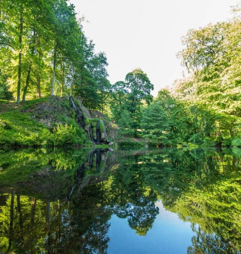 Landschaftsaufnahme mit Luisenthaler Wasserfall und Teich im Schlosspark Altenstein